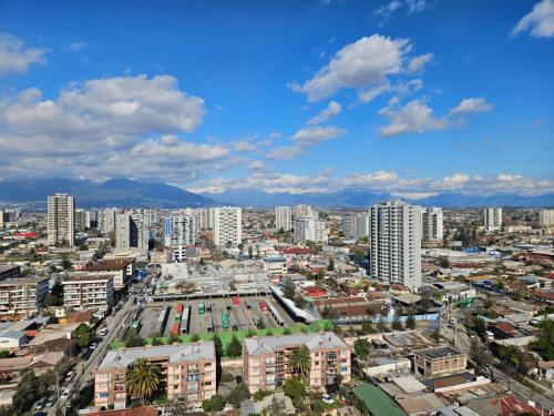 een stad met hoge gebouwen en een blauwe lucht bij Depto Carvajal in Santiago