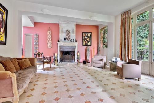 a living room with a couch and a fireplace at Villa Boileau - Welkeys in Paris