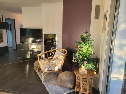 a living room with a christmas tree and a chair at Villa26 in Montauroux