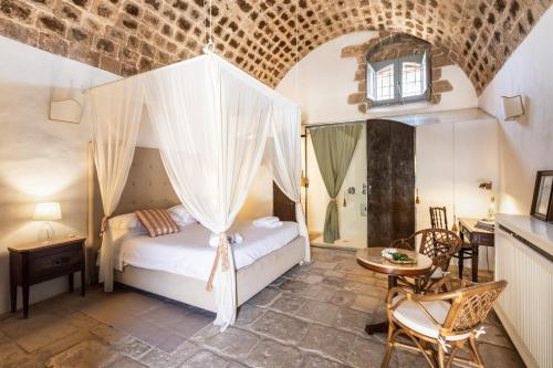 1 dormitorio con 1 cama, mesa y sillas en Masseria Costanza, Vendicari Retreat en Noto