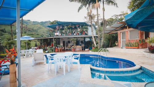 un patio con mesa y sillas junto a una piscina en Apartamento campestre para pareja en Manizales en Manizales