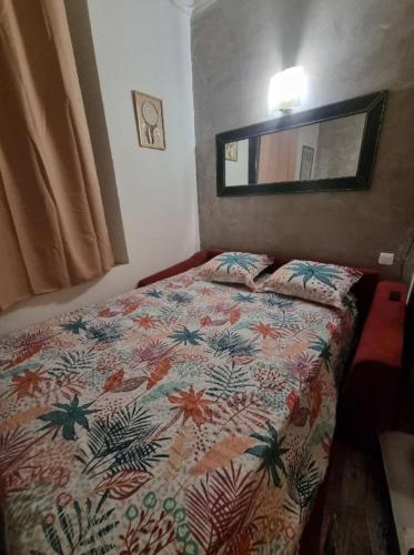 une chambre avec un lit avec une couette colorée dans l'établissement Studio le RED SOFA, cœur de ville, à La Ciotat