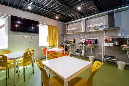 a room with two tables and chairs and a kitchen at Green Cube Capsule Hostel in Sofia