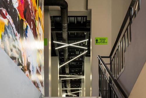 a hallway with stairs with paintings on the wall at Green Cube Capsule Hostel in Sofia