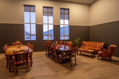 a dining room with a table and chairs and a couch at Studlagil INN Hostel in Skjöldólfsstaðir