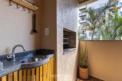 a bathroom with a sink and a window at Lindo apto a 650m da UFSC Floripa-SC IDC0102 in Florianópolis