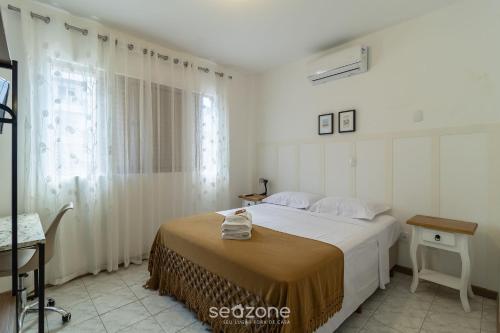 a bedroom with a large bed and a window at Lindo apto a 650m da UFSC Floripa-SC IDC0102 in Florianópolis