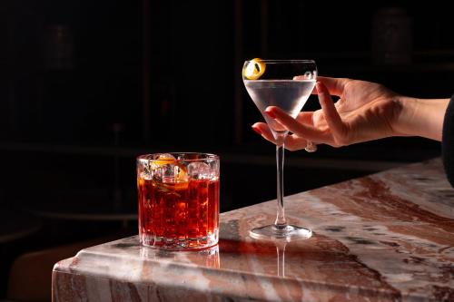 a person holding a martini glass on a table at The Address Glasgow in Glasgow