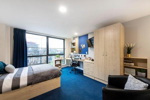 um quarto com uma cama, uma secretária e uma janela em Cosy Modern Studios at Sheffield 3 located near the University of Sheffield em Sheffield