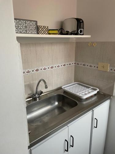 a kitchen with a sink and a counter top at Dos Ambientes Deluxe Concordia Centro in Concordia
