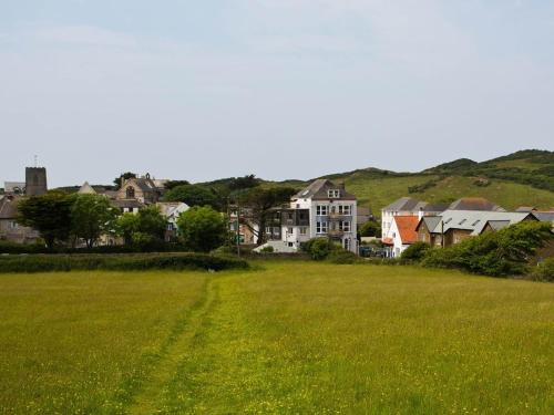 a field of green grass with houses in the background at The Smugglers Rest in Woolacombe