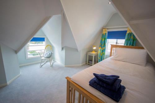 a bedroom with a bed and a chair in a attic at 3 Trinity Street in Southwold