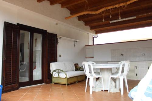 een woonkamer met een tafel en witte stoelen bij mare, sole e relax a 5 km da Cefalu' in Cefalù