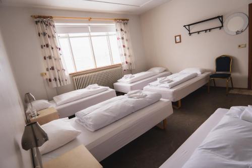 a room with four beds and a window at Studlagil INN Hostel in Skjöldólfsstaðir