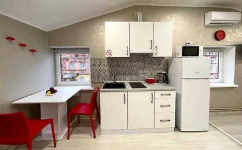 Una cocina con gabinetes blancos y un refrigerador blanco. en Old City Apartments, en Járkov