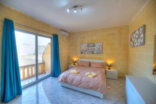um quarto com uma cama e uma grande janela em 36, Serina Court - Marsalforn, Gozo - Malta em Marsalforn