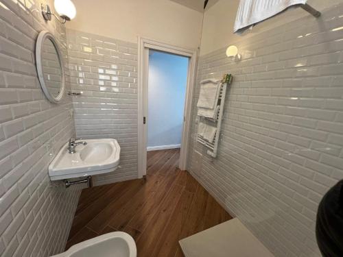 RMaison Luxury Suites Olbia في أولبيا: حمام أبيض مع حوض ومرآة