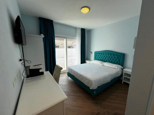 RMaison Luxury Suites Olbia في أولبيا: غرفة نوم مع سرير مع اللوح الأمامي الأزرق