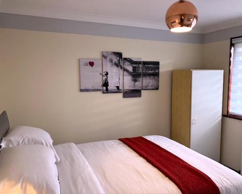 a bedroom with a white bed with a red blanket at 2 bed House with office in Historic Richmond in Richmond