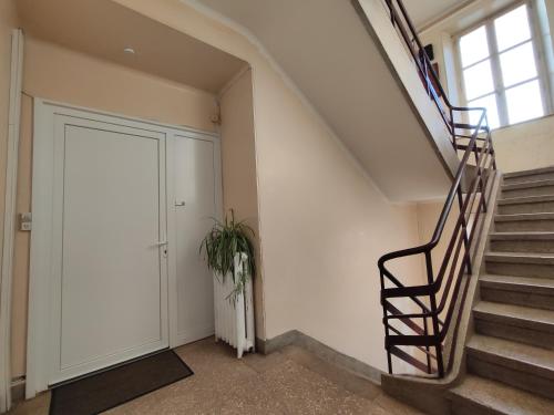 a staircase in a building with a door and a plant at Toul superbe appartement plein centre in Toul