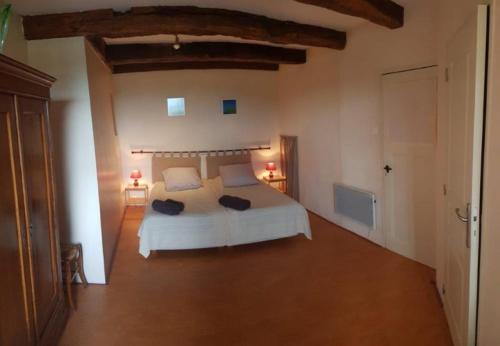 une chambre avec un lit blanc dans une pièce dans l'établissement La Tourelle, à Colombotte