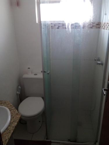 a bathroom with a toilet and a glass shower at AP in Porto Alegre