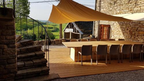 una mesa de madera y sillas en una terraza de madera en La Tourelle, en Colombotte