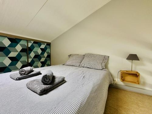 une chambre avec un lit avec deux serviettes dessus dans l'établissement Jolie maison de vacances mitoyenne au calme proche Tanchet 4 personnes, à Les Sables-dʼOlonne