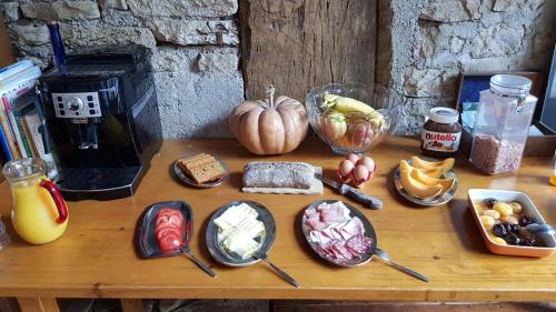 una mesa de madera con comida encima en La Tourelle, en Colombotte