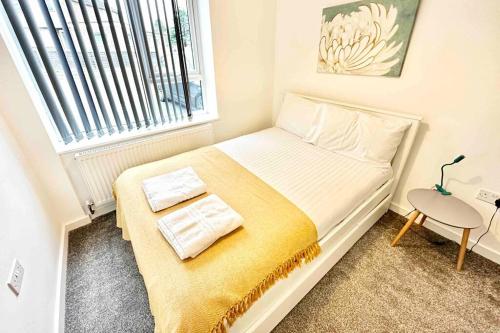 un piccolo letto in una piccola stanza con finestra di Paradigm House, Stunning 2-Bedroom Apartment 1, free Parking, Oxford a Oxford