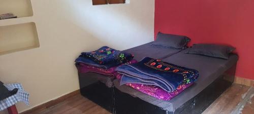 a bed with blankets on it in a room at Mahakaal HomeStay in Ujjain