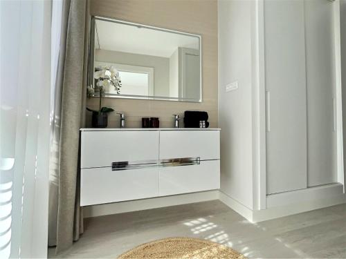 La salle de bains est pourvue d'une commode blanche avec un miroir. dans l'établissement San Roque Golf Club, Step into elegance with this 3-bedroom luxury modern townhouse close to Sotogrande, à San Roque