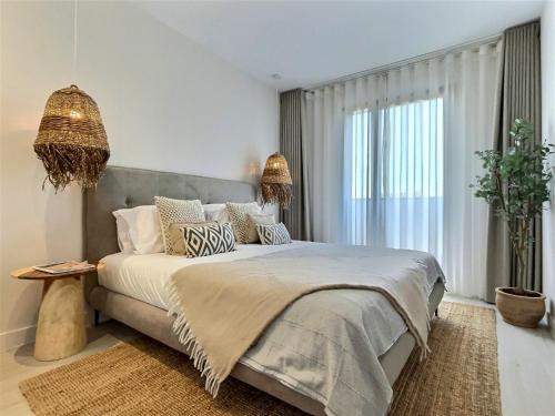une chambre avec un grand lit et une grande fenêtre dans l'établissement San Roque Golf Club, Step into elegance with this 3-bedroom luxury modern townhouse close to Sotogrande, à San Roque
