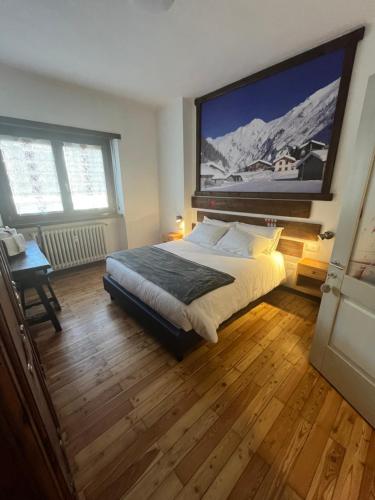 een slaapkamer met een bed met een groot scherm aan de muur bij Ca' Elide in Aosta