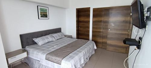 a bedroom with a bed and a wooden closet at RESORT PLAYA AZUL in Tonsupa