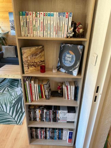une étagère remplie de livres et de DVD dans l'établissement Appartement T2 ambiance chalet centre village, à La Clusaz