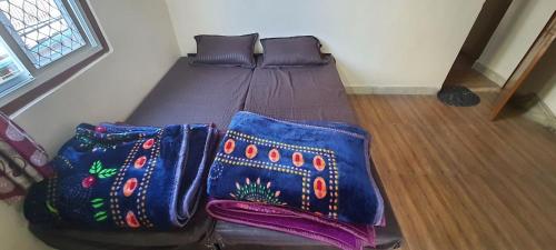 a bed with three pillows on it in a room at Mahakaal HomeStay in Ujjain