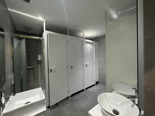 uma casa de banho com 2 lavatórios, um chuveiro e 2 WC em Madriz Hostel em Madri