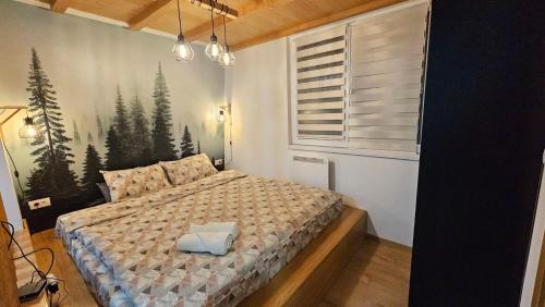1 dormitorio con 1 cama con una foto de árboles en la pared en Vila Jahor - Apartmani Trifković, en Jahorina