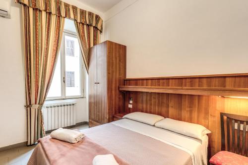 sypialnia z dużym łóżkiem i oknem w obiekcie Hotel Giada Roma w Rzymie