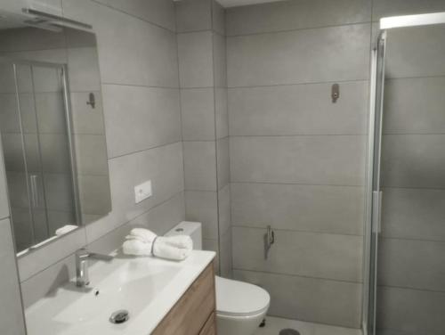 Un baño con ducha, lavabo e inodoro. en Apartamento Bulevar Cangas, en Cangas de Morrazo