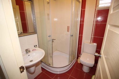 a bathroom with a shower and a toilet and a sink at Turan Hotel in Atakum