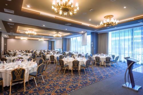 uma sala de banquetes com mesas, cadeiras e lustres em Hilton Garden Inn Lima Surco em Lima