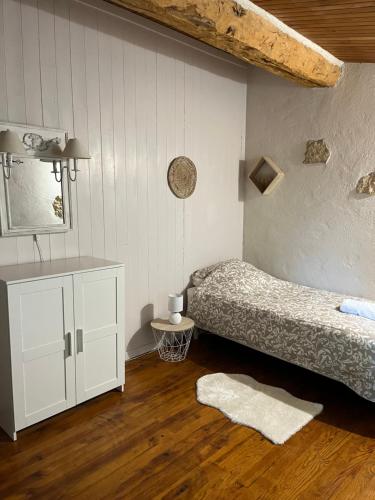 a bedroom with a bed and a dresser and a mirror at Domaine Saladry in Villepinte