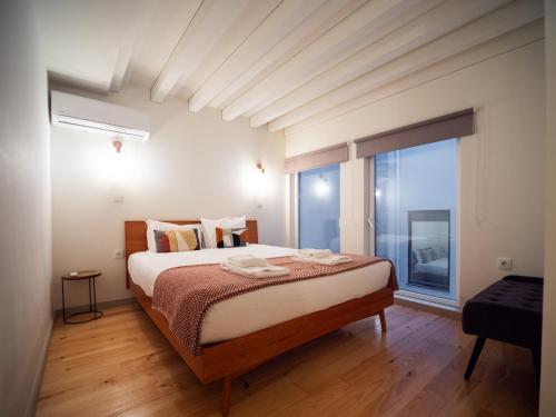 a bedroom with a bed and a large window at Oporto City View- Trindade luxury in Porto