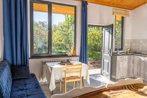 ein Wohnzimmer mit einem Tisch und eine Küche mit Fenstern in der Unterkunft Art Rooms Garni (Blue Edition) in Garni