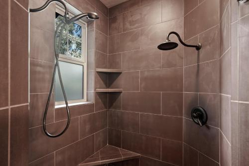 een badkamer met een douche met bruine tegels bij Blakely 30 Day Minimum in Bend