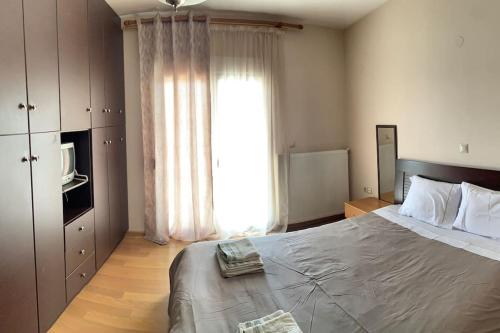 a bedroom with a large bed and a large window at ΔΙΧΩΡΟ ΔΙΑΜΕΡΙΣΜΑ ΣΤΗΝ ΚΑΣΤΟΡΙΑ in Kastoria