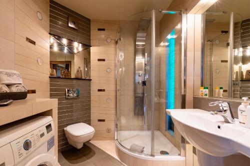 a bathroom with a shower and a sink and a toilet at Apartament Rondo VERONA - Darmowy parking dla Gości in Wrocław