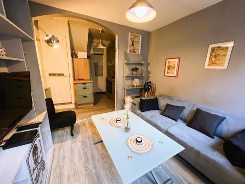 uma sala de estar com um sofá e uma mesa em Maison de pêcheurs Malvina em Le Tréport